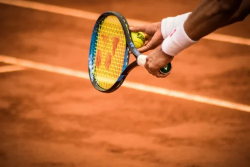 A tennis player getting ready to serve