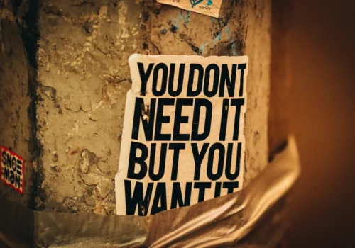 A sign saying "You don't need it, but you want it"