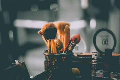A set of makeup brushes in dim lighting