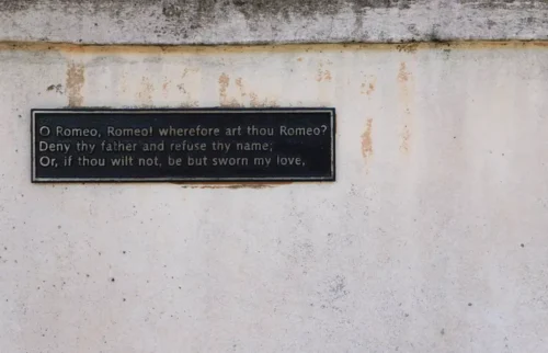 A quote of Romeo and Juliet on a metallic plaque on a wall